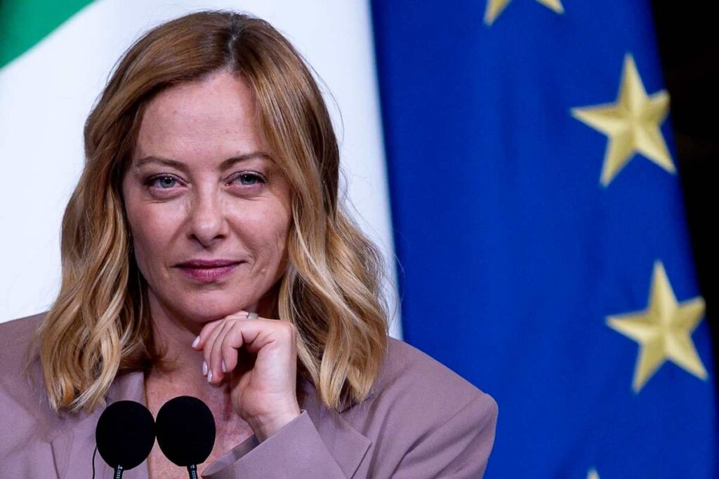 il premier giorgia meloni con dietro la bandiera dell'Unione europea