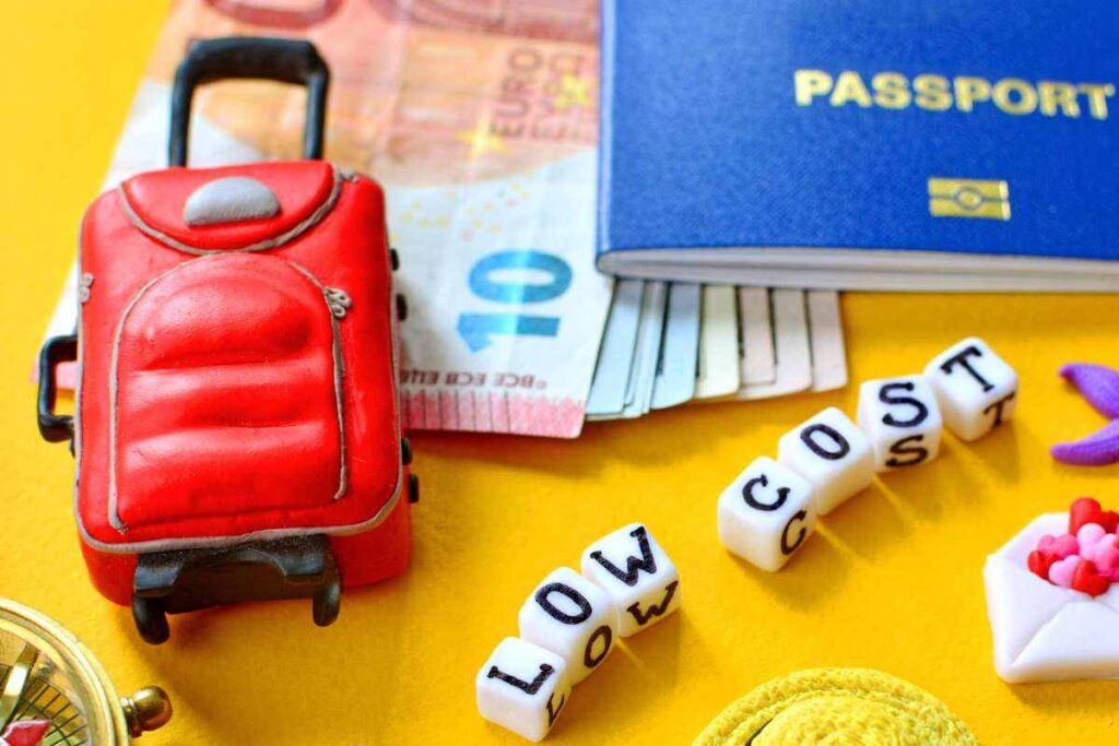 mini valigia, banconote, passaporto e scritta