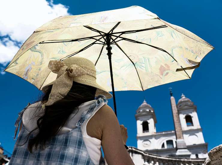 Una donna si protegge dal sole con l'ombrello