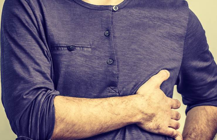 Un uomo che si tocca le costole
