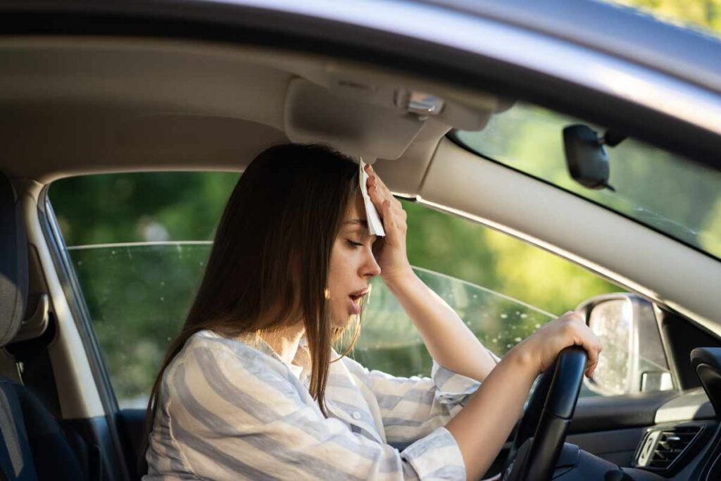 Una donna che soffre il caldo in auto