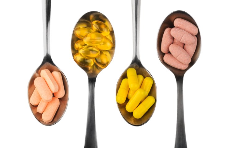 Cucchiai pieni di integratori diversi