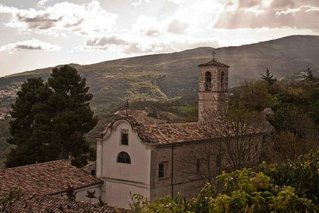 vallata con montagne sullo sfondo e un palazzo