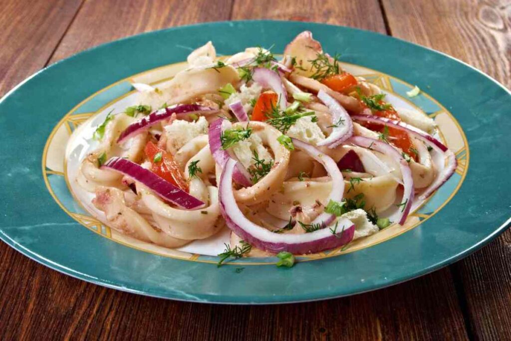 piatto di insalata di calamari con cipolle ed erbe