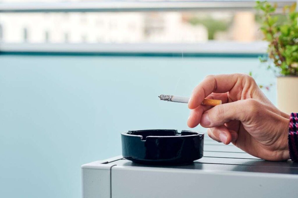 Persona che fuma in balcone