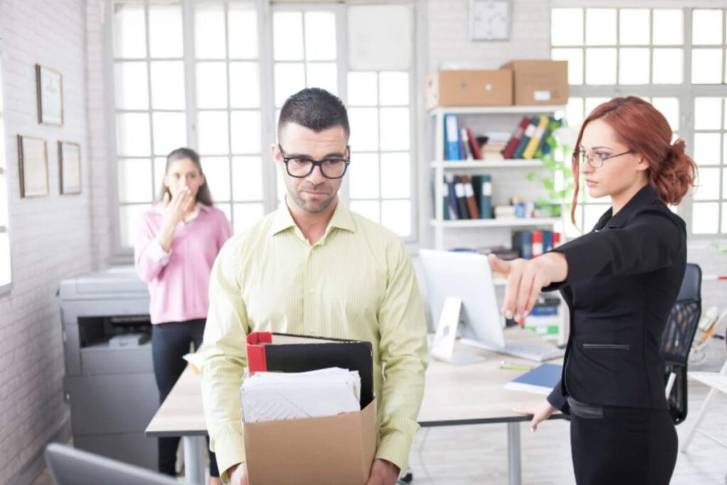 uomo licenziato con in mano uno scatolone pieno di cose