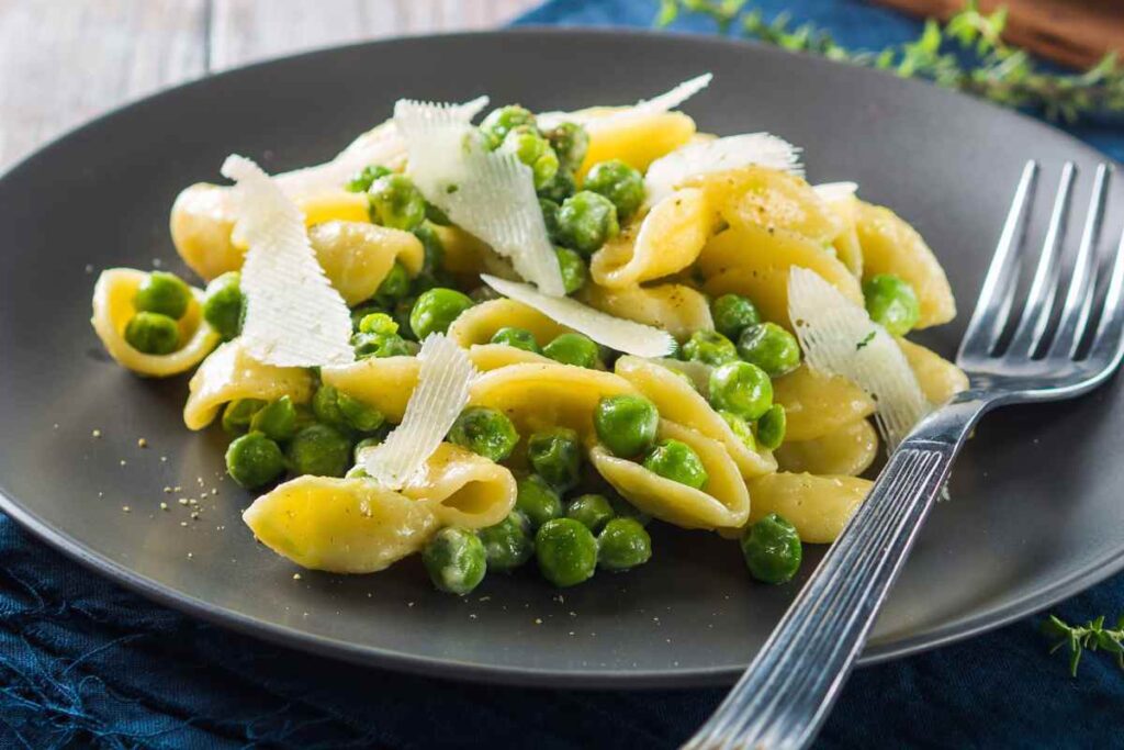piatto di cappelletti con piselli e formaggio a scaglie