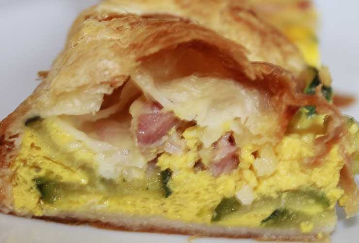 pezzo di pizza ripiena con salumi, formaggio e uovo sbattuto