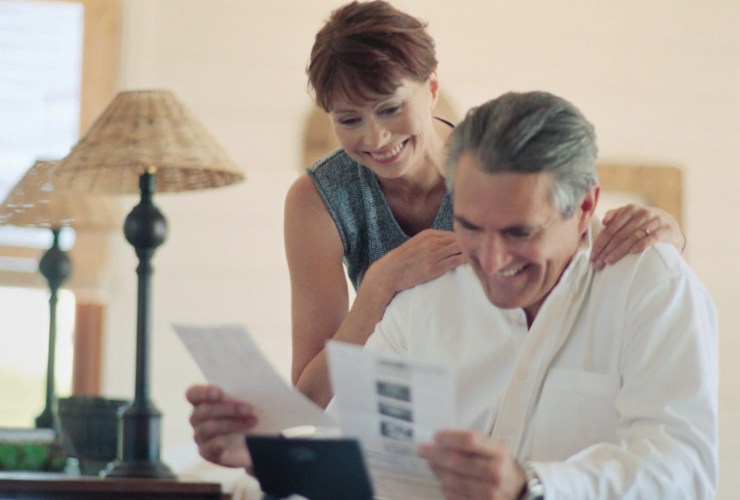 uomo e donna che sorridono mentre guardano dei fogli
