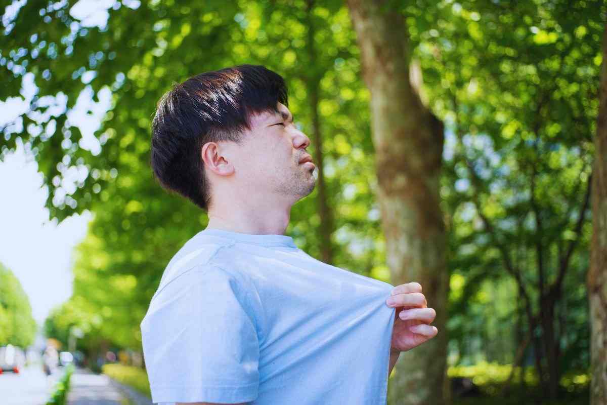 Uomo accaldato si solleva la maglietta per fare entrare aria