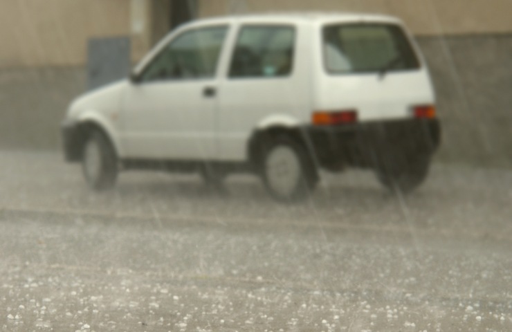 Pioggia battente in atto ed una Fiat 500 vecchia
