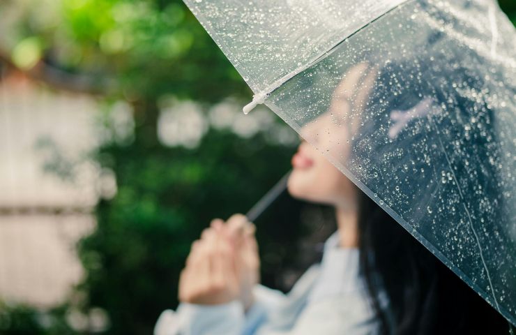 Una donna con un ombrello mentre piove
