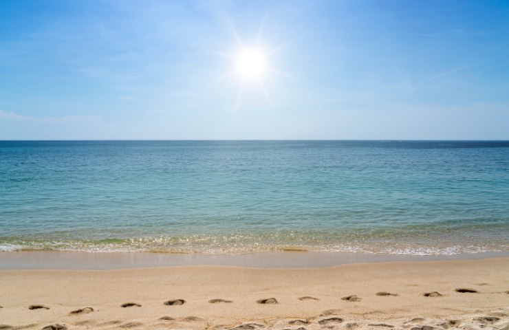Una giornata di sole al mare con orme sulla spiaggia