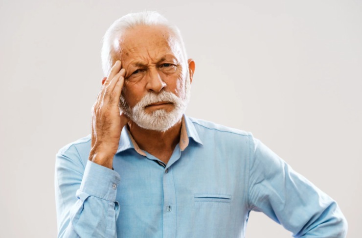 uomo anziano preoccupato con una mano su una tempia