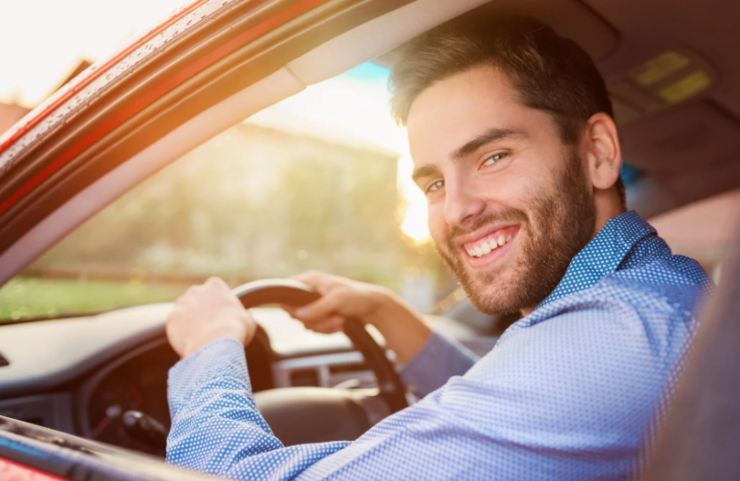 uomo che sorride a bordo dell'auto