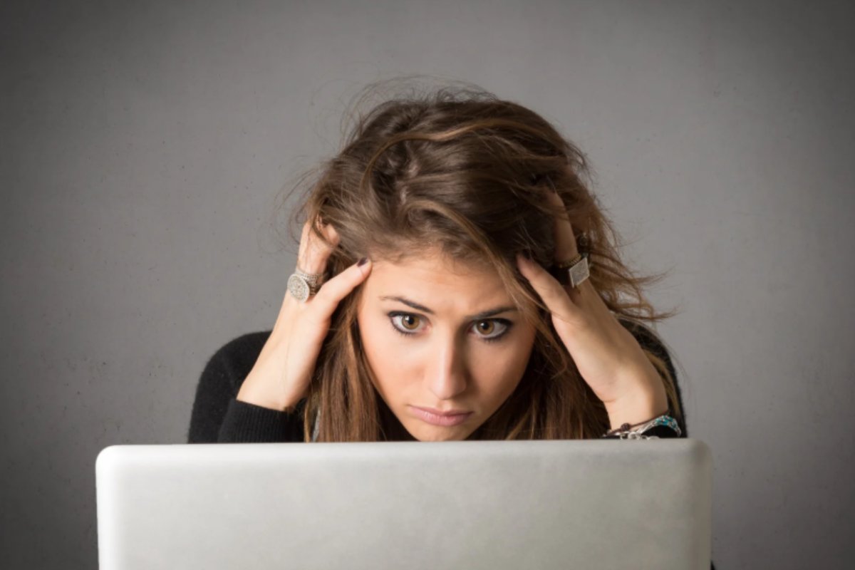 donna seduta davanti al computer con le mani nei capelli