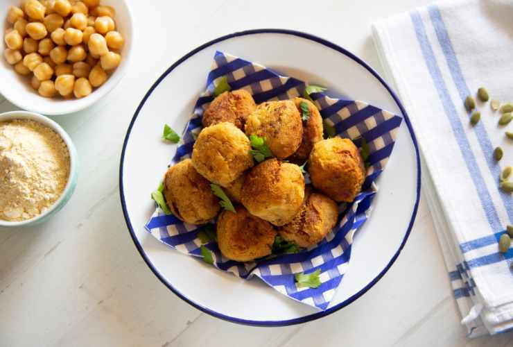 crocchette di ceci nel piatto, ciotola di parmigiano e ceci interi