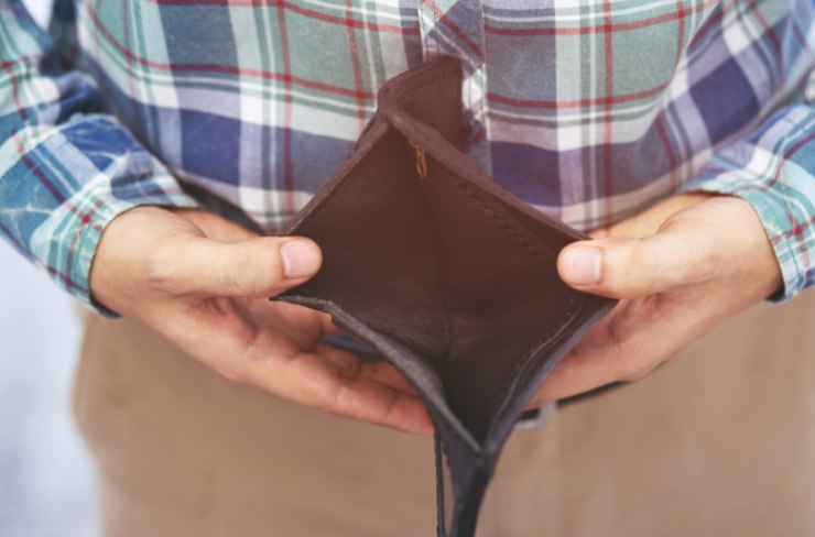 uomo con in mano un portafoglio vuoto