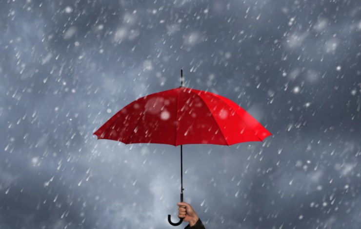 pioggia e persona con in mano un ombrello rosso