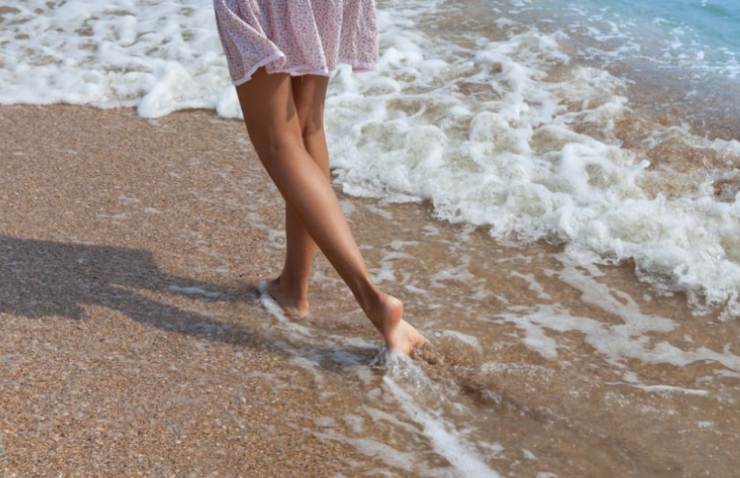 donna cammina sulla sabbia
