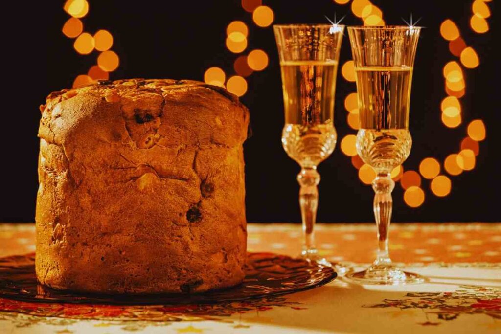 panettone e prosecco su tavolo con lucine