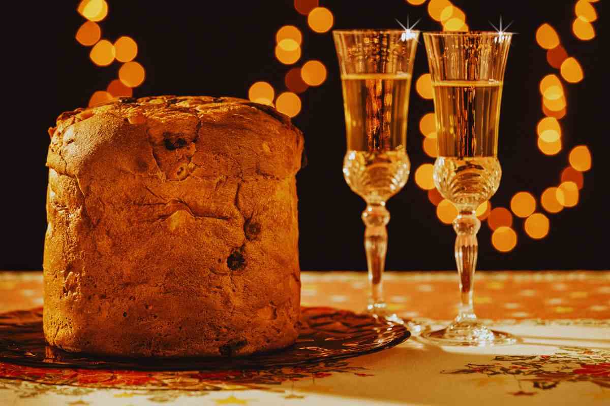 panettone e prosecco su tavolo con lucine