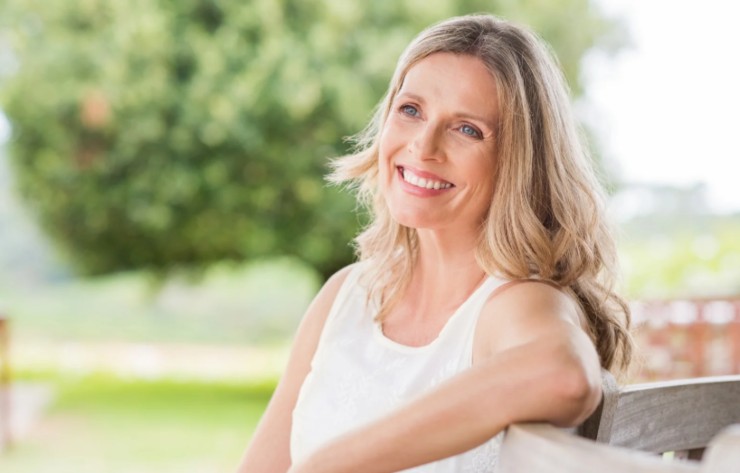 donna che sorride seduta in un giardino