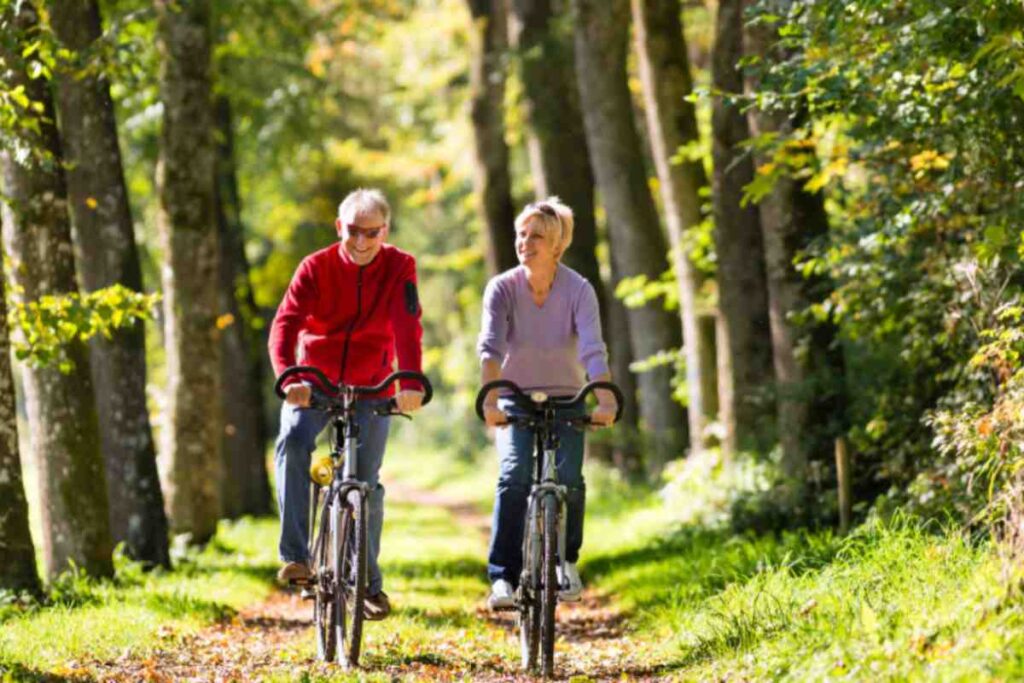 uomo e donna in bicicletta in mezzo al verde