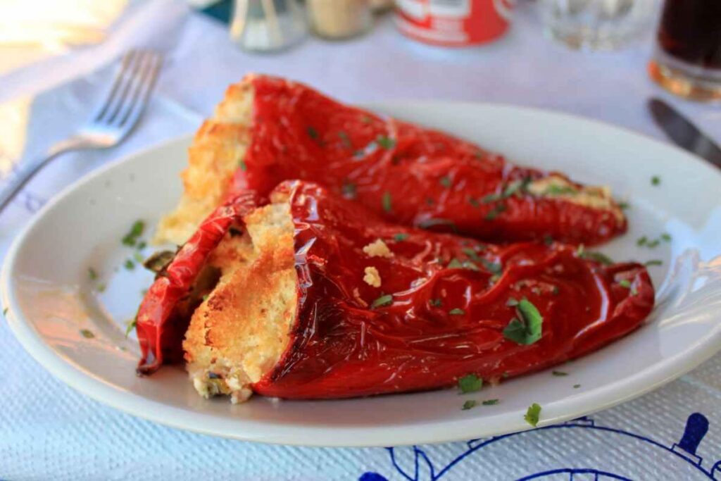 piatto a tavola con due peperoni ripieni