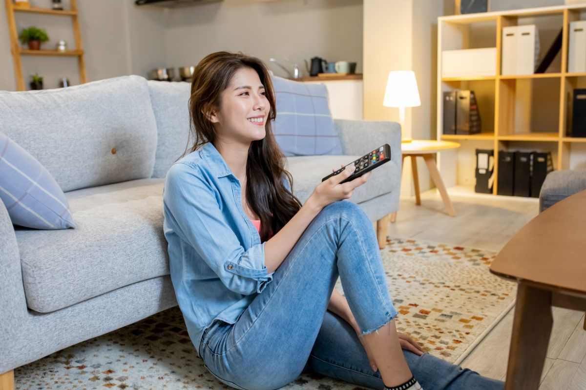 donna che gira canali alla televisione