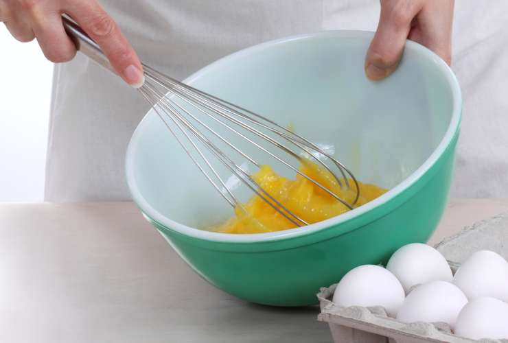 sbattere le uova con una frusta in una ciotola