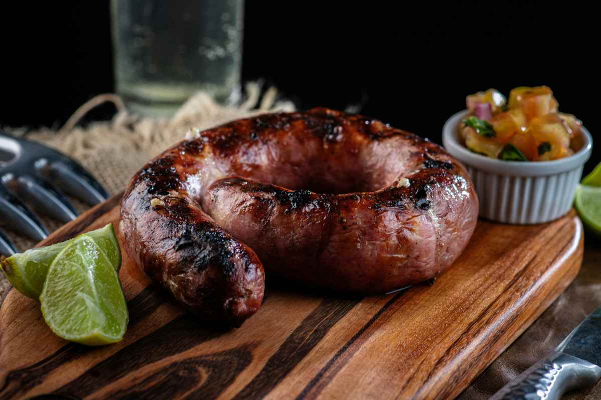 salsiccia cotta intera sul tagliare con due fette di lime accanto