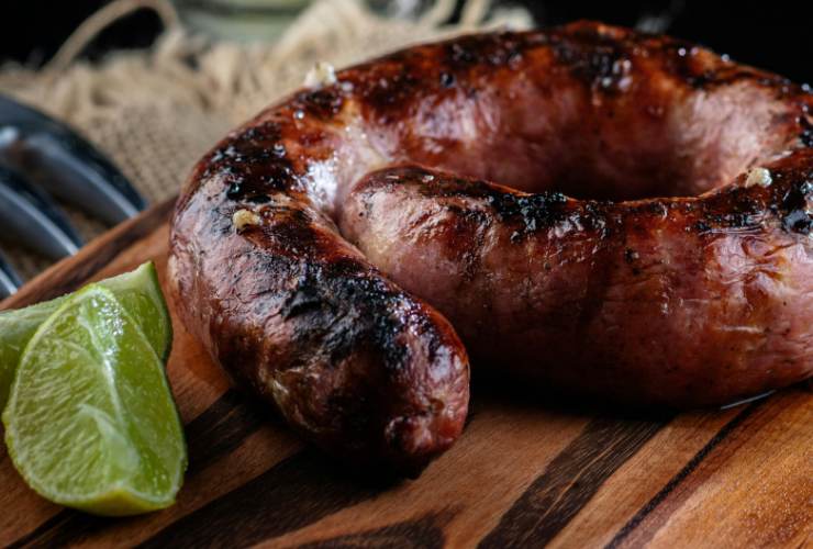 salsiccia intera cotta sul tagliare e fette di lime