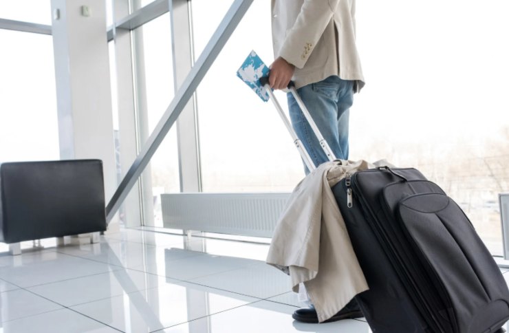 persona in aeroporto con una valigia