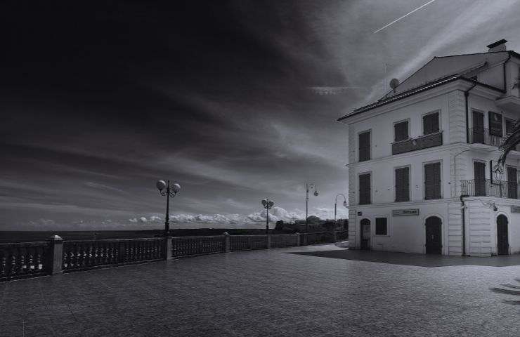 paesaggio in bianco e nero con casa e cielo nuvoloso