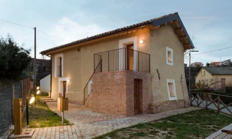 una casa con le scalette e il cielo al tramonto