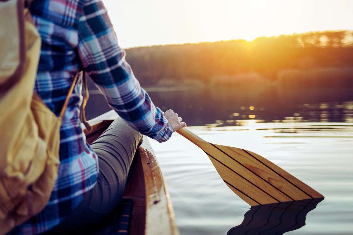 donna che va in canoa al tramonto