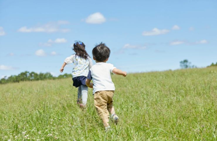 due bambini che corrono su un prato
