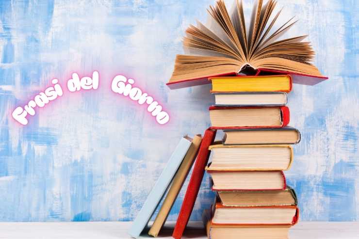 scritta frasi del giorno e libri impilati