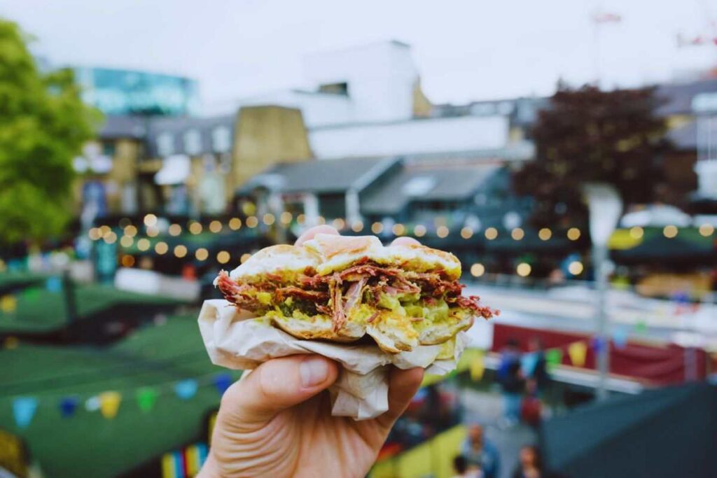 panino in una mano e dietro una fiera