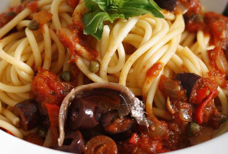 spaghetti con acciughe capperi e olive nere
