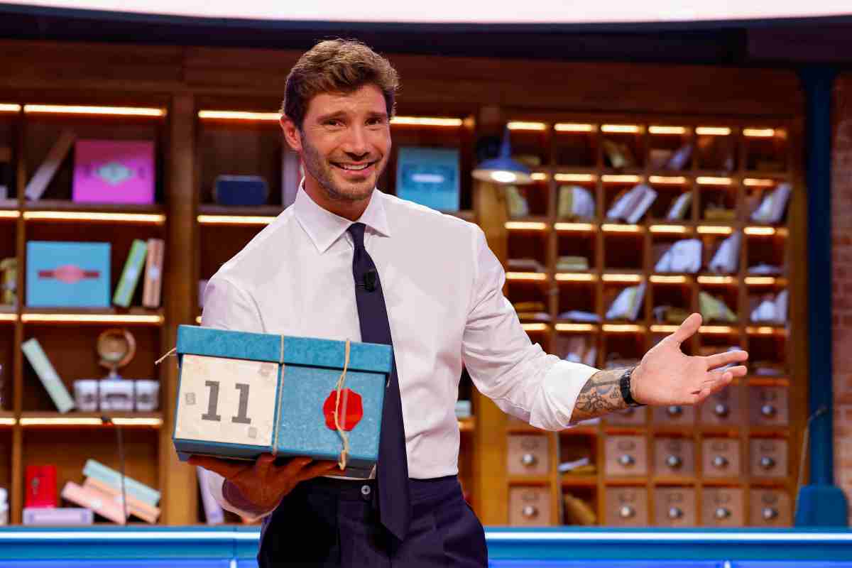 Stefano De Martino sorride con un pacco di Affari Tuoi