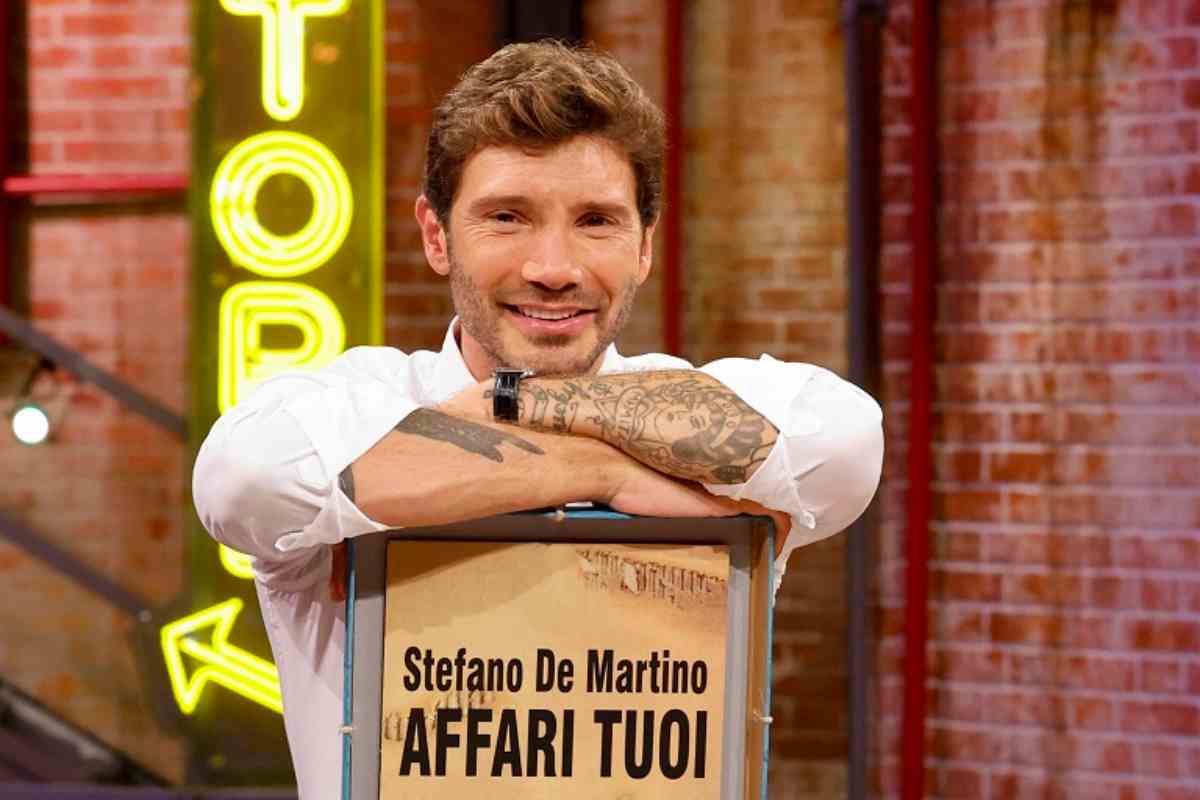 Stefano De Martino posa con un pacco di Affari Tuoi