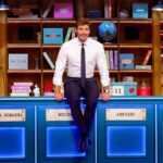 Stefano De Martino seduto sui banconi di Affari Tuoi