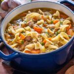 pentola con minestra di pasta, verdure, carne e legumi