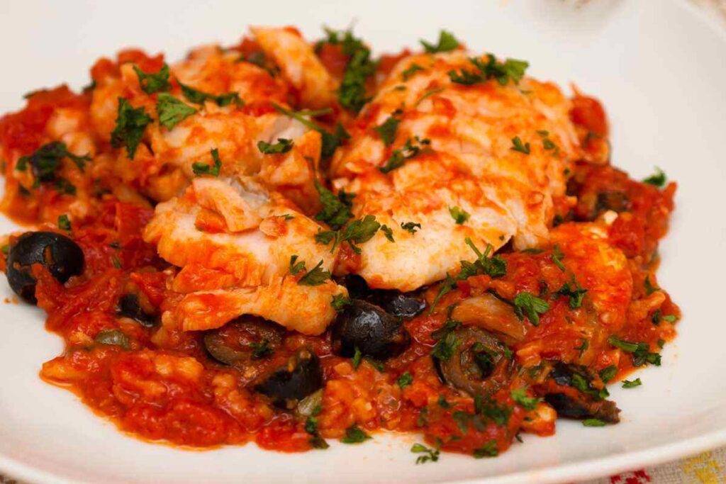 piatto con baccalà con pomodoro e olive fumante