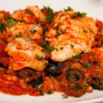 piatto con baccalà con pomodoro e olive fumante