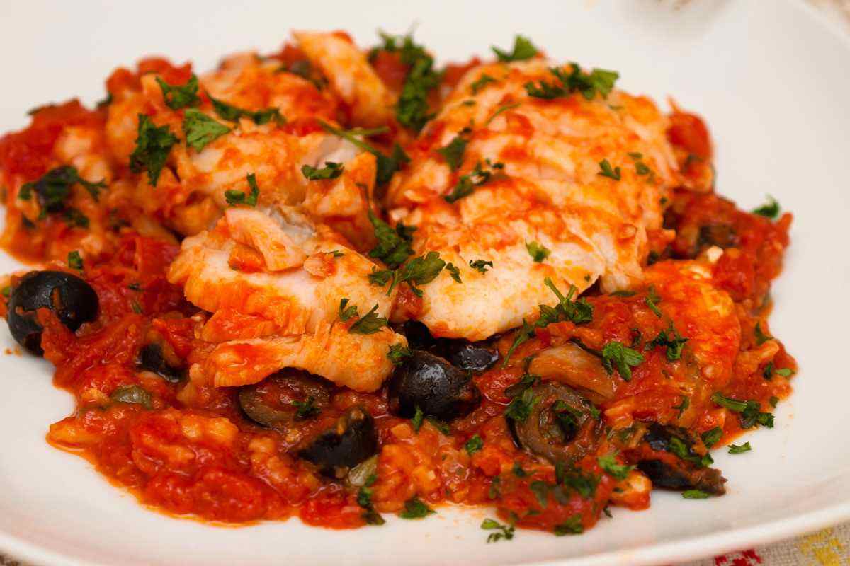 piatto con baccalà con pomodoro e olive fumante