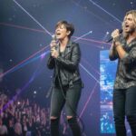 un cantante ed una cantante che cantano su un palco