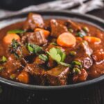 piatto con carne cotta in umido, carote e prezzemolo